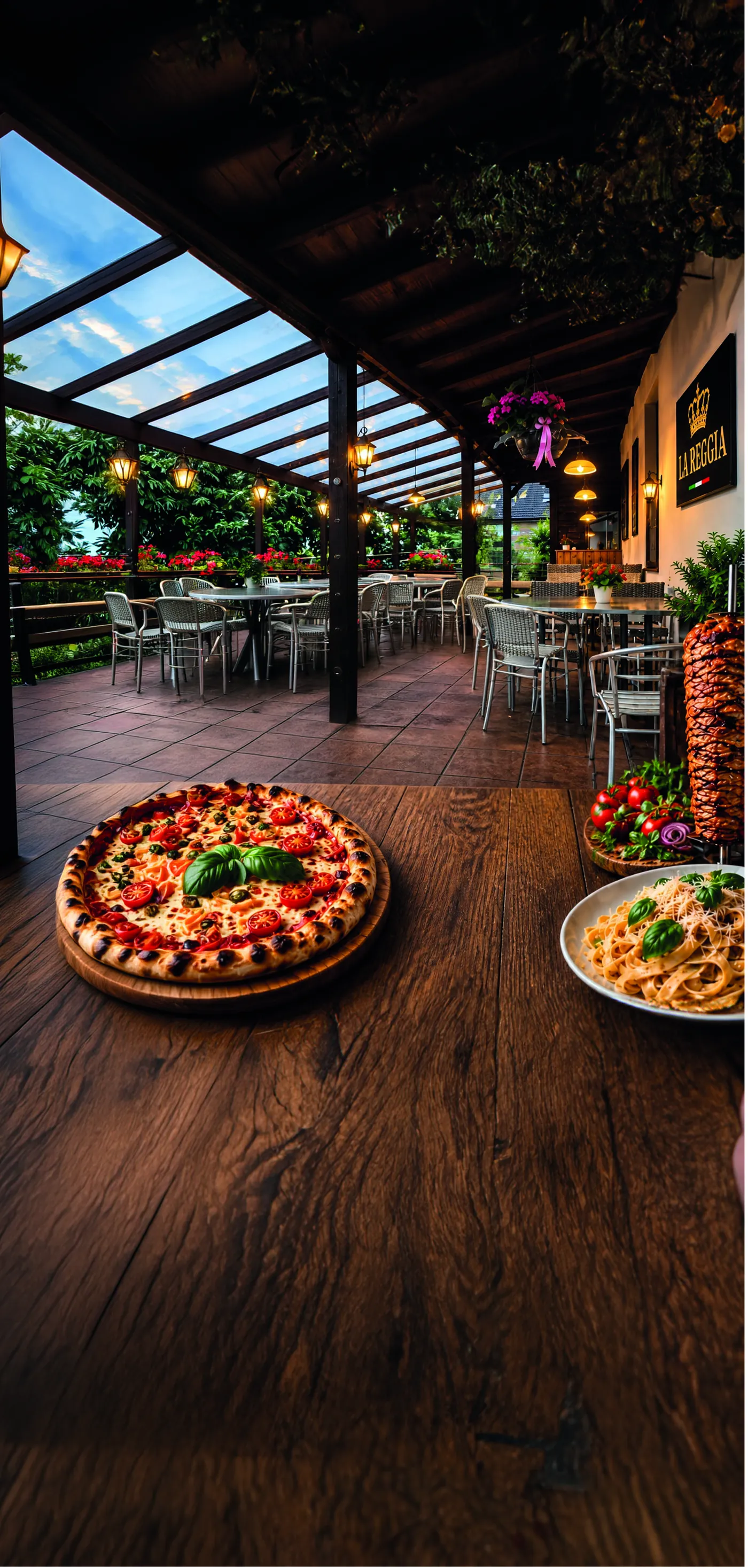 Terrasse des Restaurants La Reggia mit Pizza und Pasta auf dem Tisch